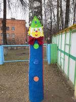 Забавные клоуны украшают деревья на участках детского сада.